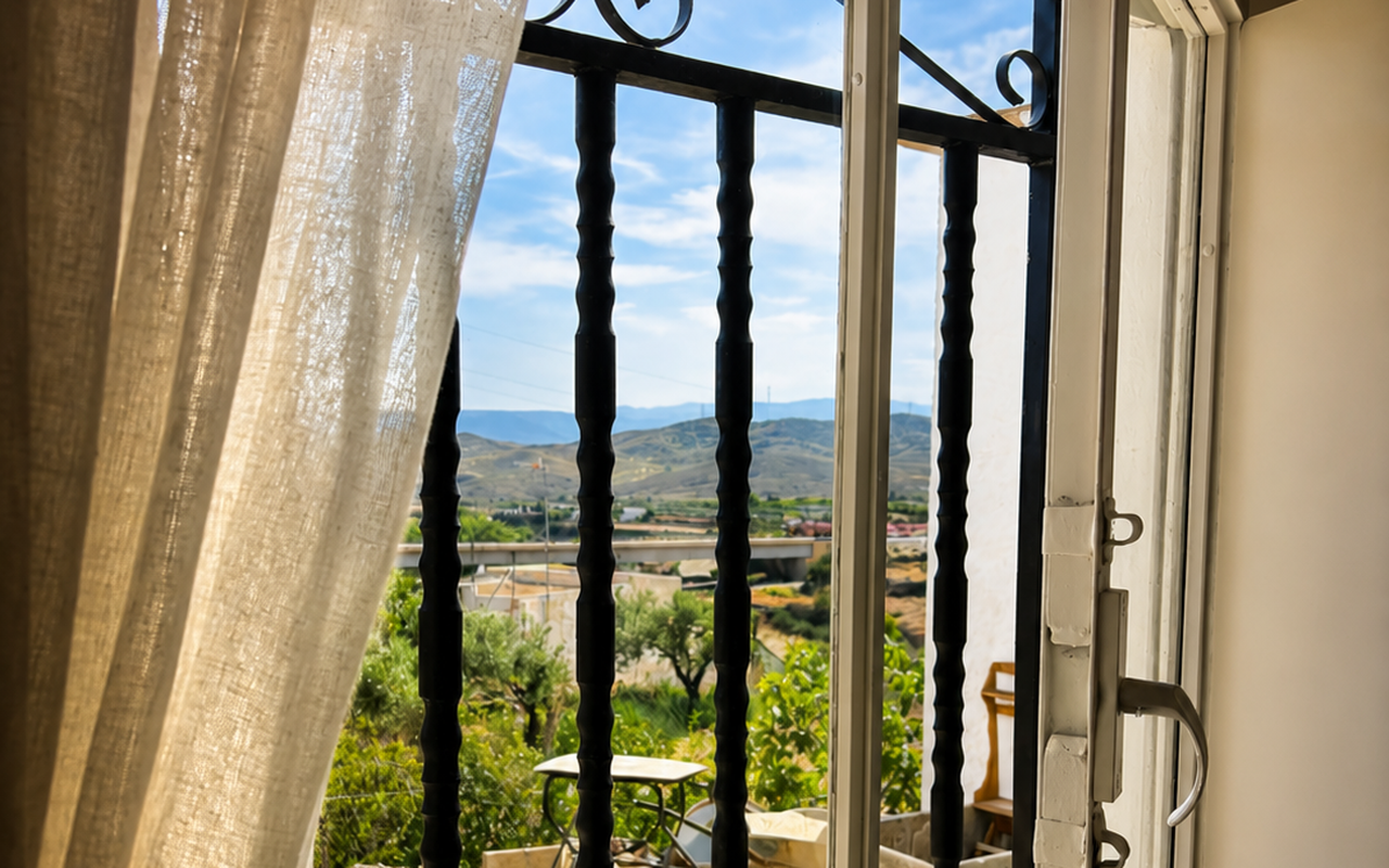 Ventana de la casa abierta al valle de Gérgal al atardece