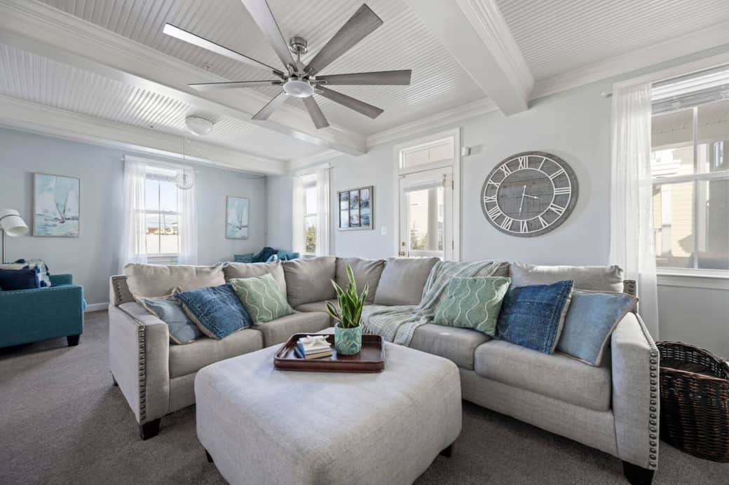 Cozy living room- 1 big sectional, 2 sofas, fireplace and ceiling fan.