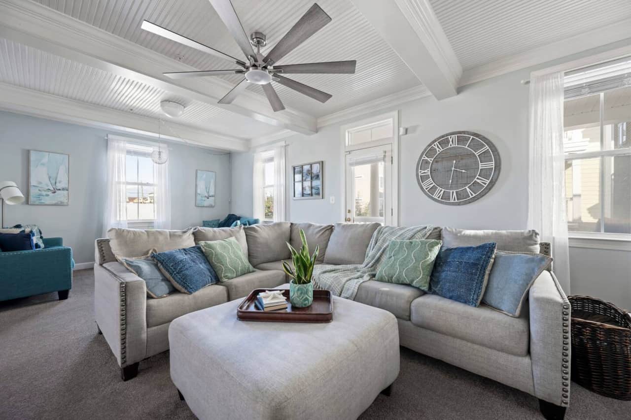 Cozy living room- 1 big sectional, 2 sofas, fireplace and ceiling fan.
