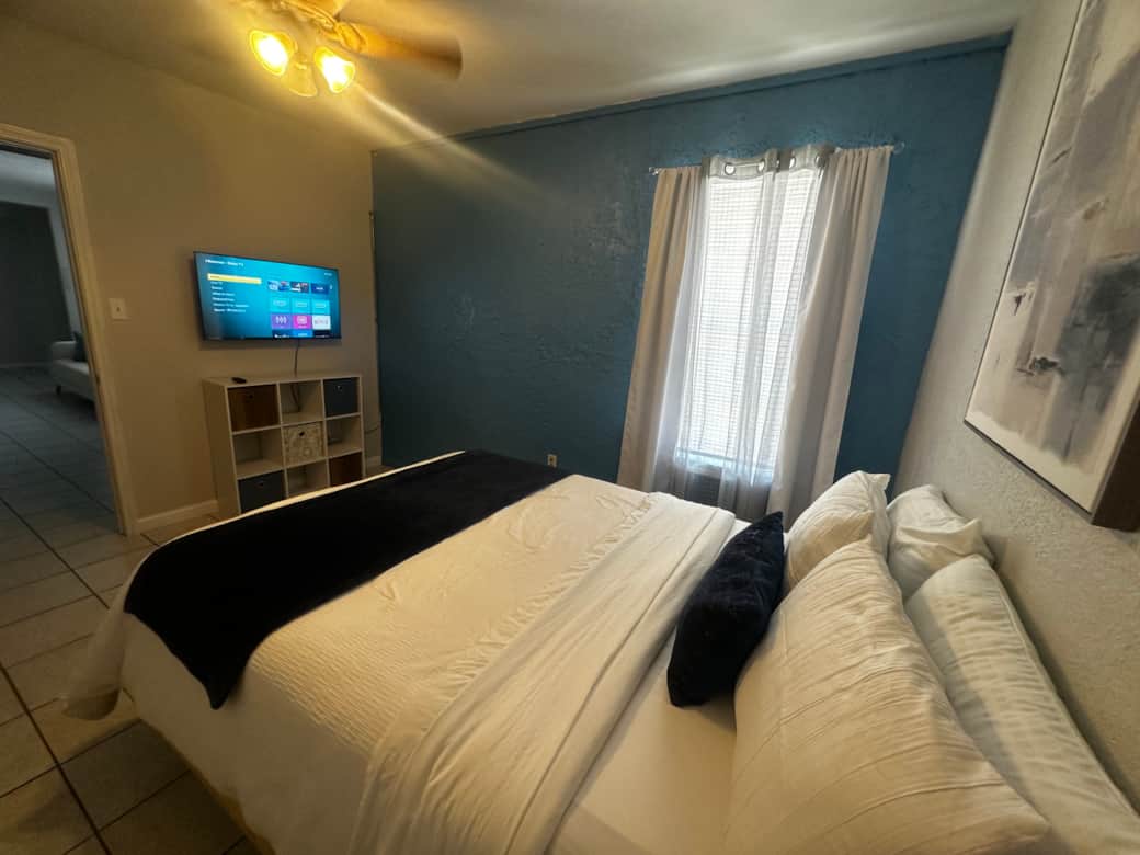 Queen Bedroom with big TV and charging station nightstand 