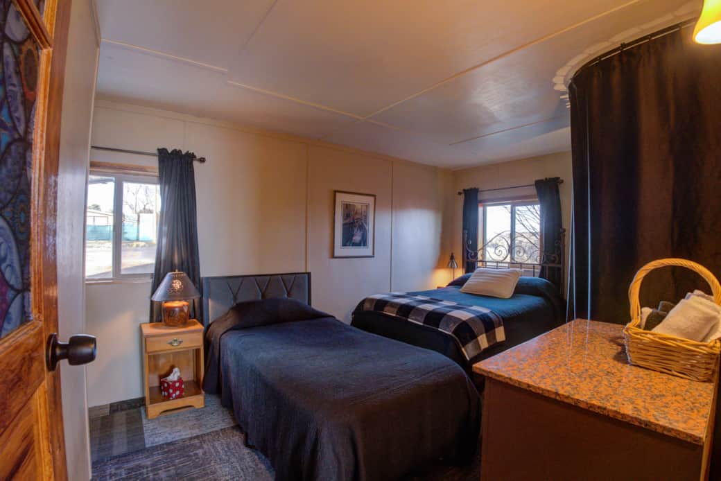 Bedroom 2 features a double bed and a single bed, and the washer/dryer behind the curtain.