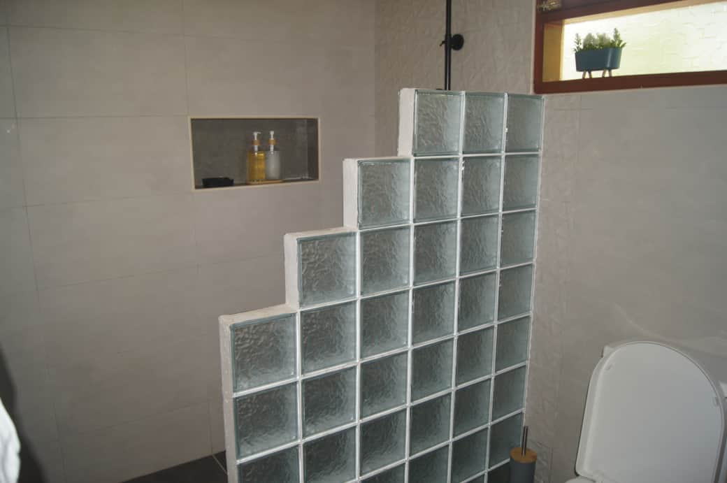 The Blue Bedroom Bathroom - Glass brick wall ensures privacy and no shower water splashes