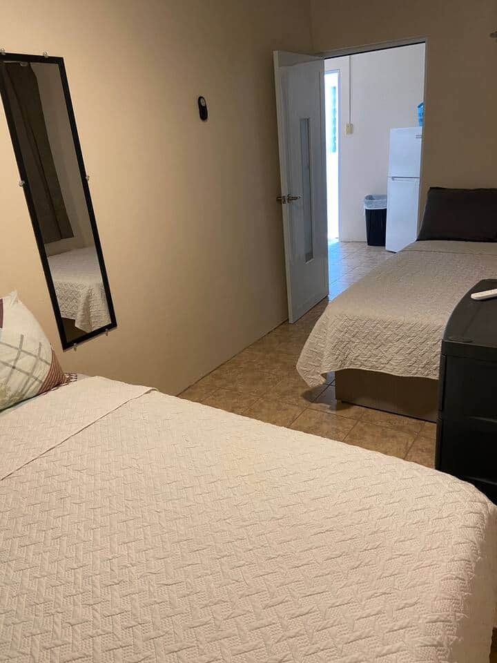 A bedroom with 2 confortable full beds to accommodate up to 4 people. An inverter air conditioned, ceiling fan, a mirror and a drawer. 