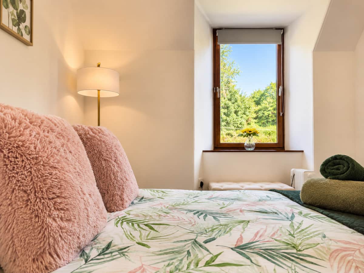 Soft pink cushions and botanical bedding in Bedroom 3, Isle of Skye.