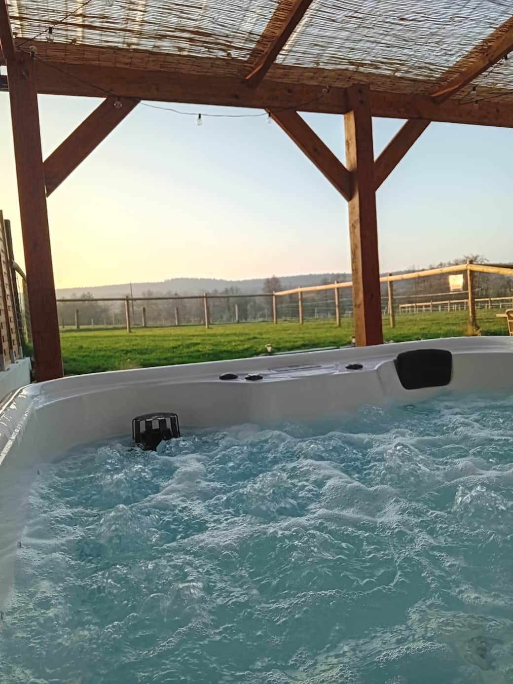 Jacuzzi privatif, sur la terrase du gîte, sous la pergola, vue sur notre troupeau de Pottoks