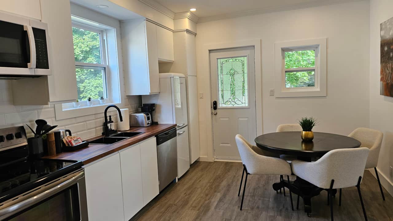 Open kitchen and dining area with seating for four, natural light, and efficient layout in a downtow