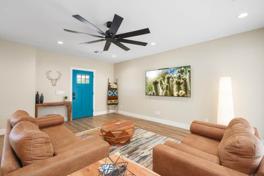 Welcoming entryway with a massive wall-mounted Smart TV and comfortable lounge seating.