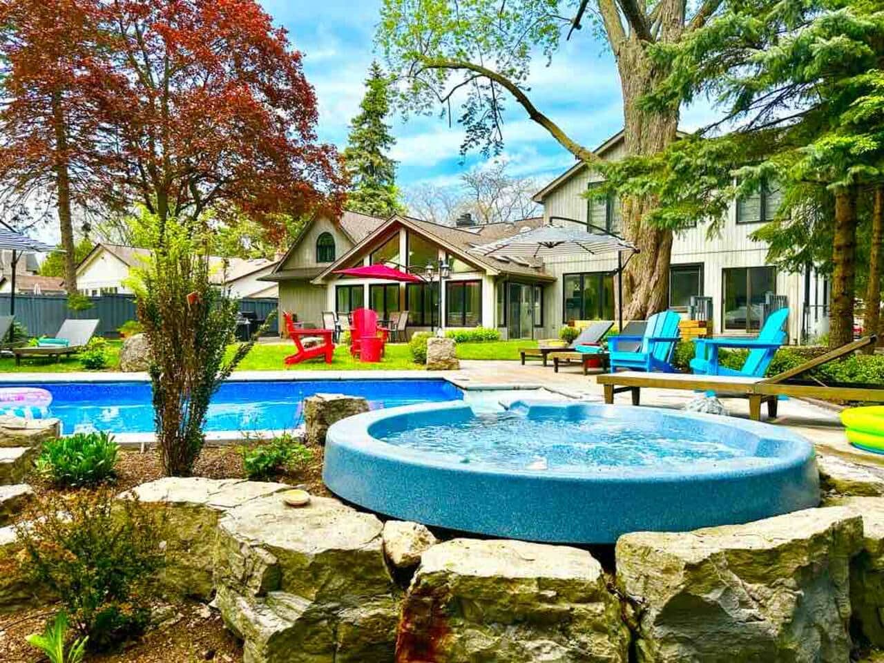 Our backyard offers a true resort like feel with a pool and connected tub, water fall, lounge chairs and a view of the beautiful ravine. 
