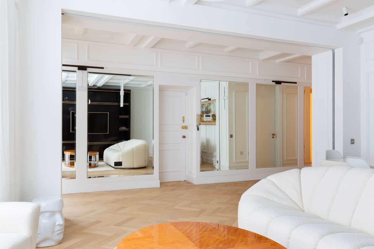 Mirrored hallway reflecting the elegant open-plan living space