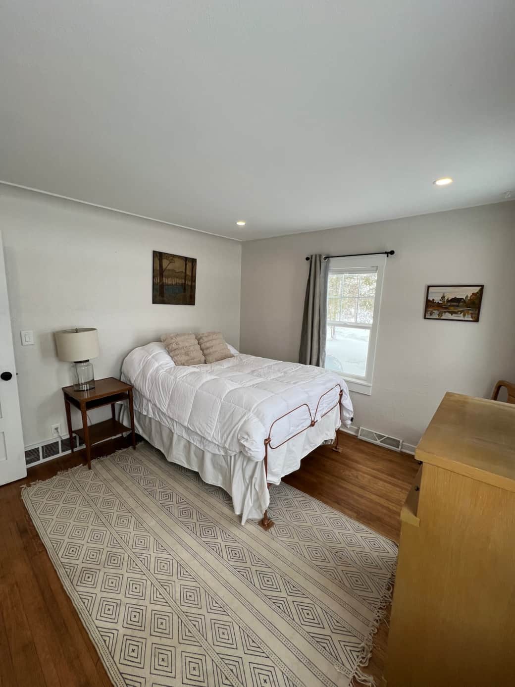 Main floor bedroom 1 with full bed, blackout and light filtering curtains and a 40" smart tv with di