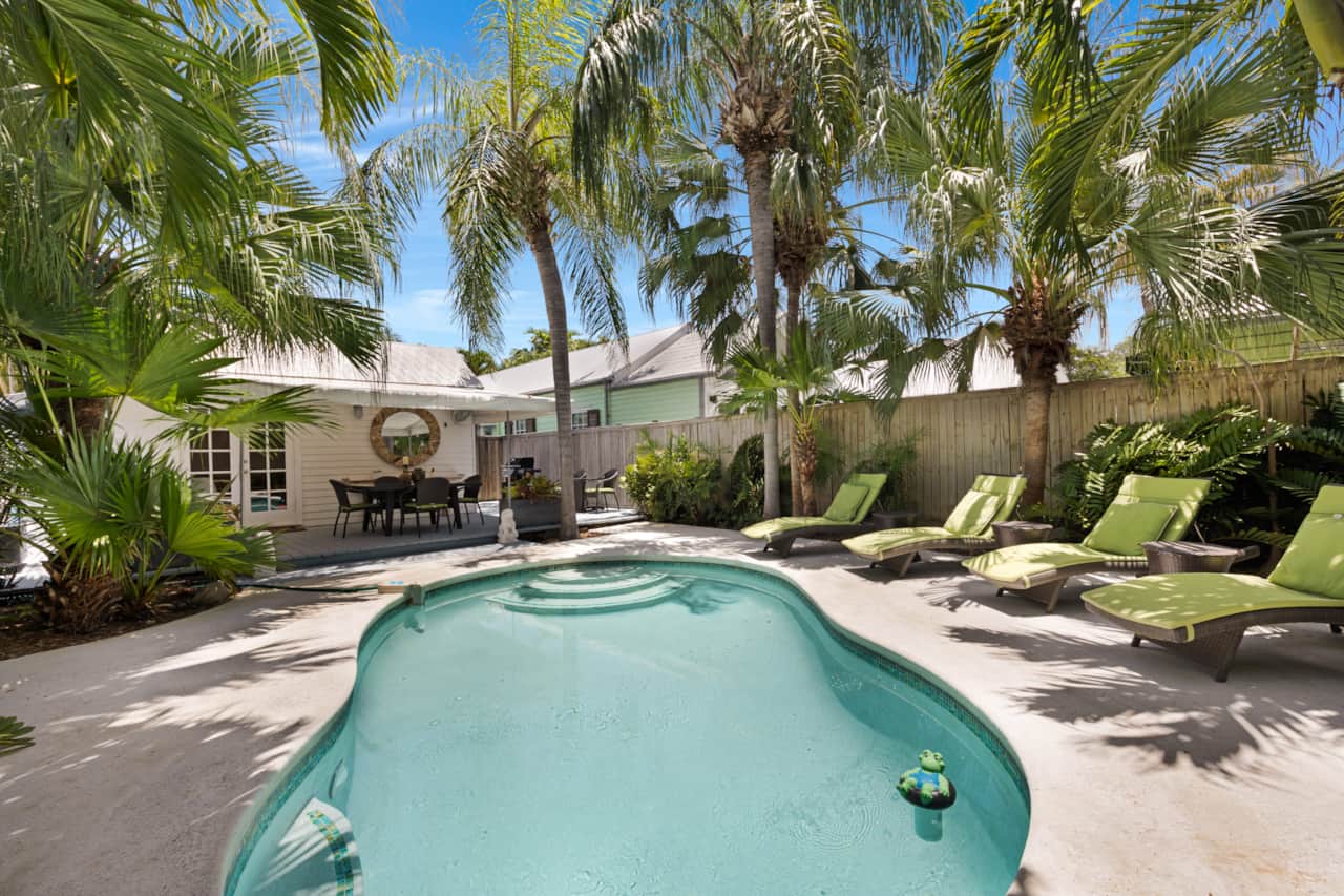 Welcome to Valhalla with private heated pool framed by palms, tropical greenery, and lounge seating.