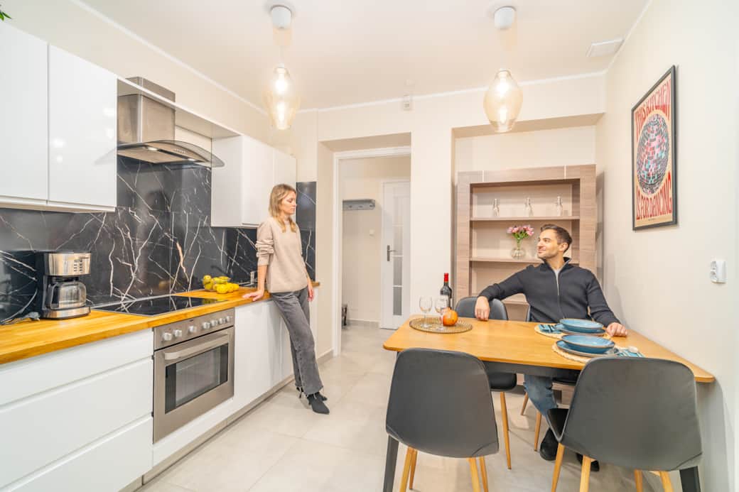 Modern kitchen with dining area, wooden countertop and table for four guests.