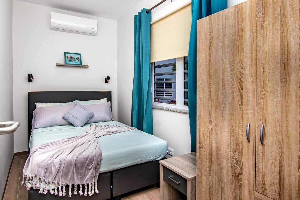 Small bedroom with 140 x 200 cm bed, bedside table and wardrobe.