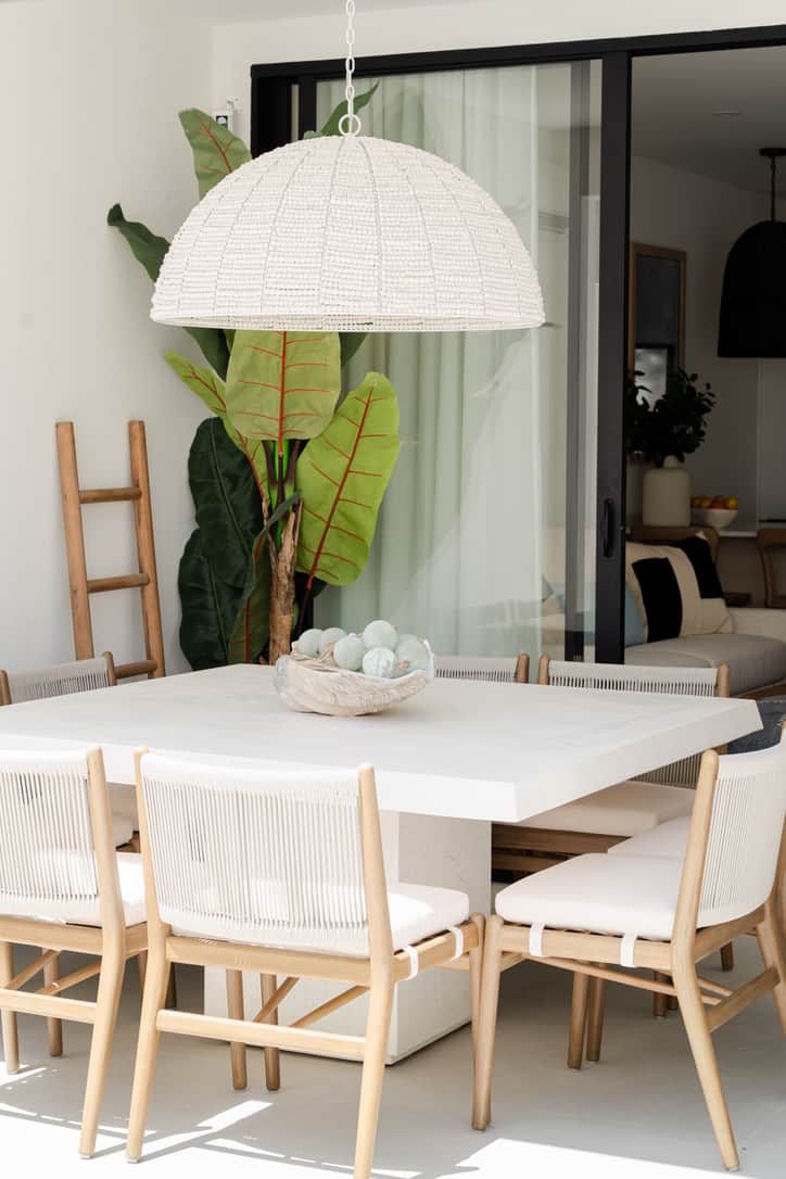 Covered alfresco dining area overlooking pool and garden.