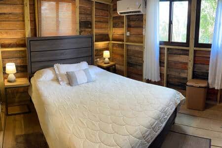 Cabin-style bedroom with queen bed, air conditioning and ensuite bathroom 