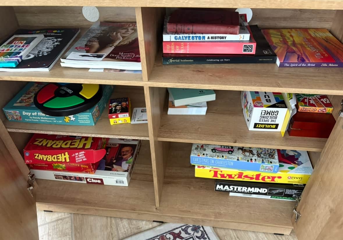 Under-TV console with games and puzzles for guests.