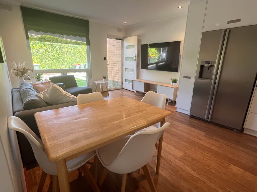 TrooBloo Glenelg North Unit | Dining table looking over seating area TrooBloo Glenelg North Unit | Dining table looking over seating area