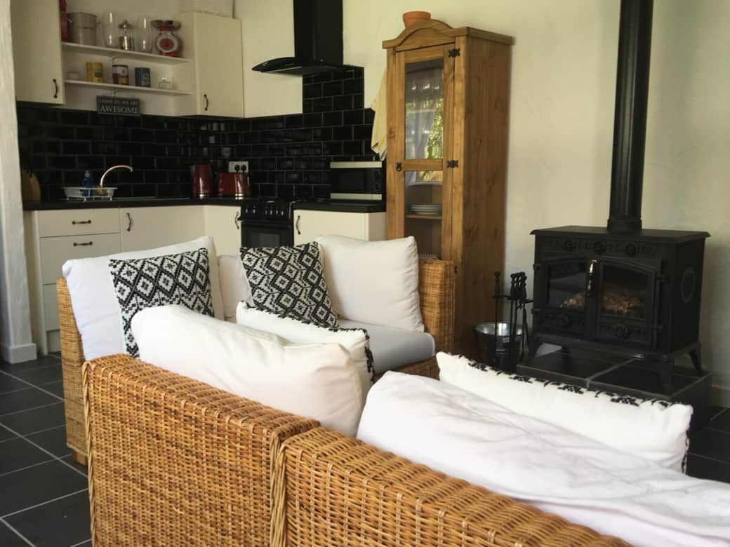 Open plan living room kitchen with a wood burner stove.
