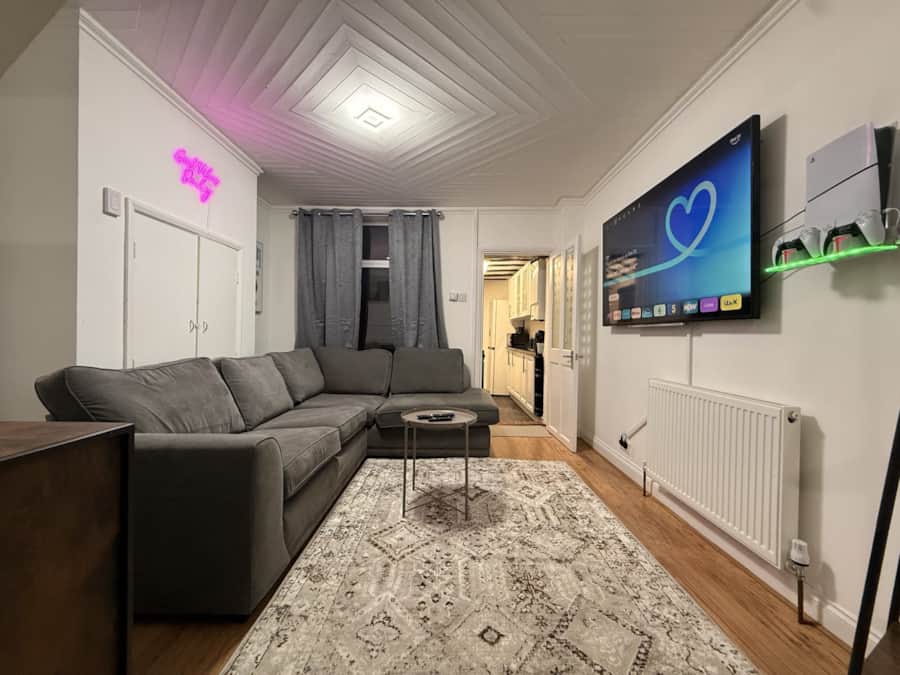 Living room with a grey corner sofa and smart TV in a Haven Homes property