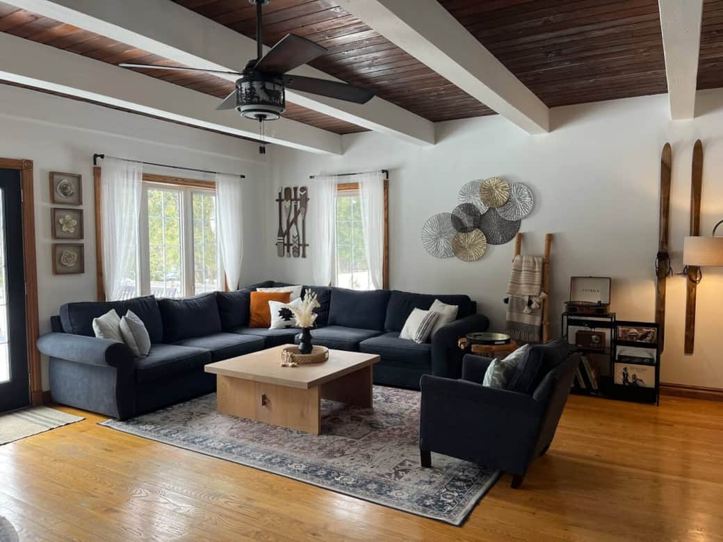 Family room with sectional couch, cuddler couch, electric fireplace, 65 inch smart TV, and vinyl record player.