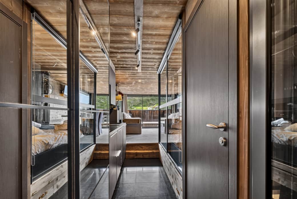 A warm, wooden hallway leads to the bedroom, bathroom, and living room. A warm, wooden hallway leads to the bedroom, bathroom, and living room.