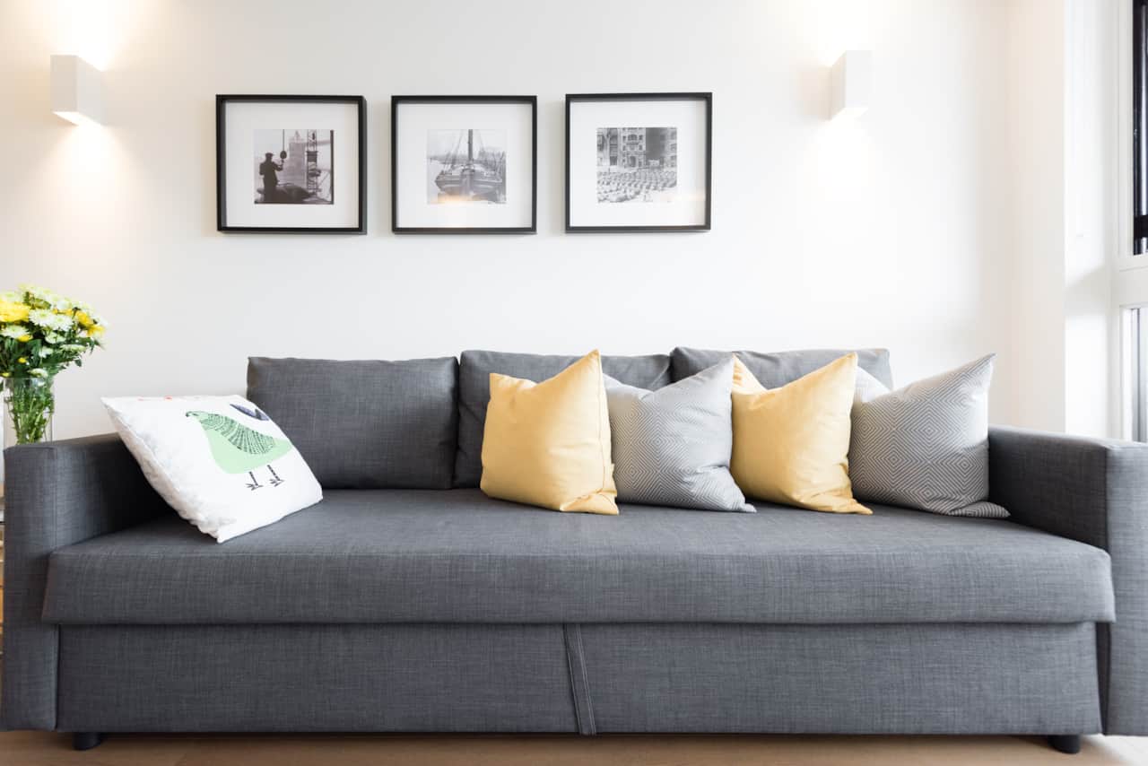 Comfortable grey sofa styled with mustard and patterned cushions