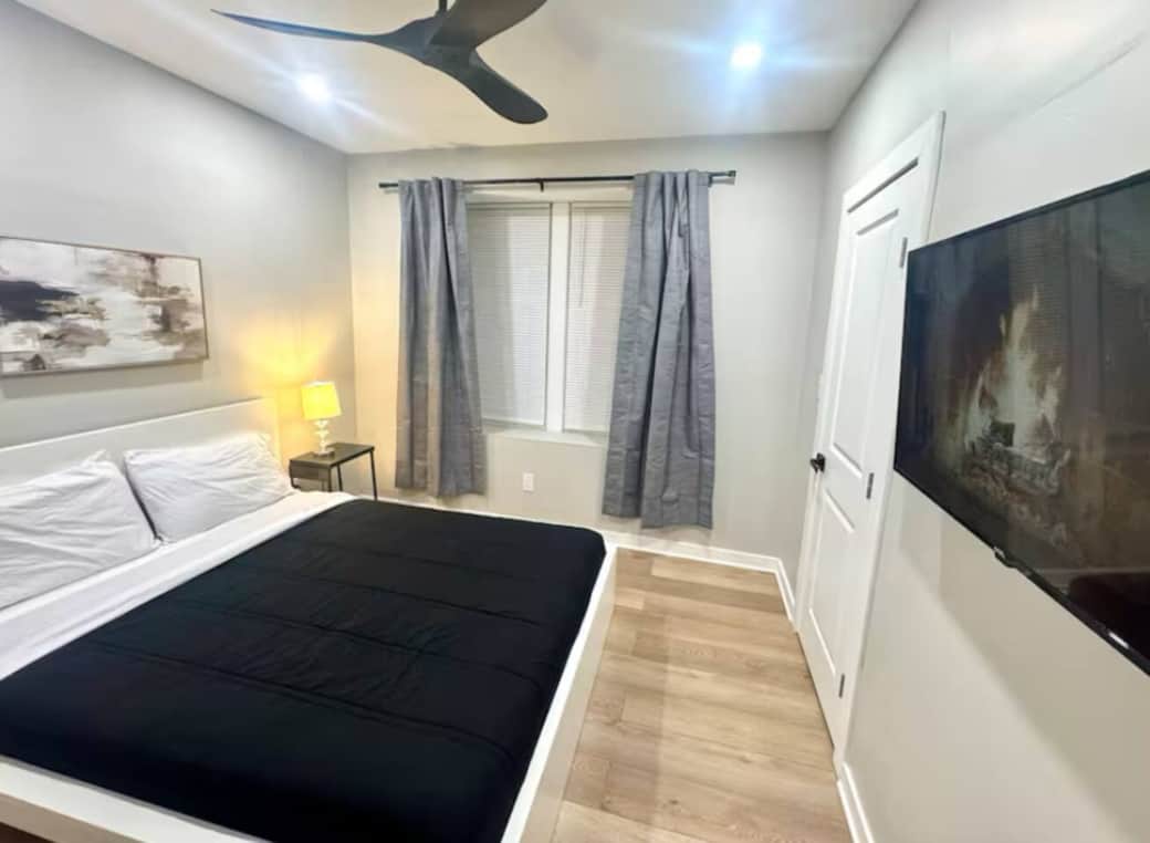 This comfortable bedroom includes a queen bed, flat-screen TV, ceiling fan, darkening curtains, a side table, USB charging, lamp, and a spacious closet for all your storage needs.