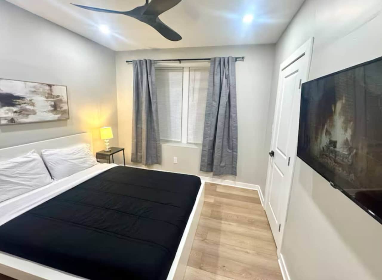 This comfortable bedroom includes a queen bed, flat-screen TV, ceiling fan, darkening curtains, a side table, USB charging, lamp, and a spacious closet for all your storage needs.