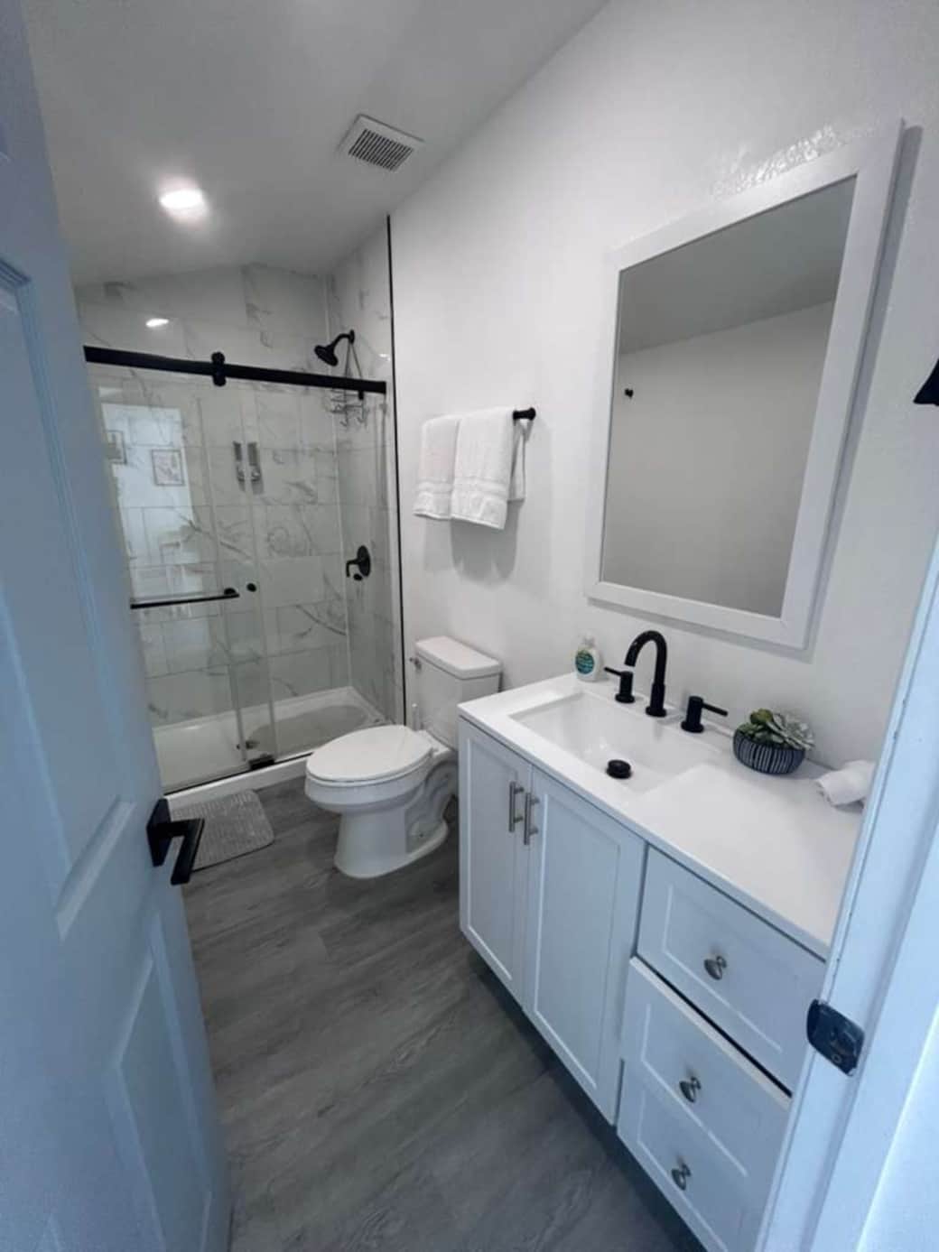 Modern bathroom with a glass shower, vanity, mirror, and spotless finishes. Lakeland, FL