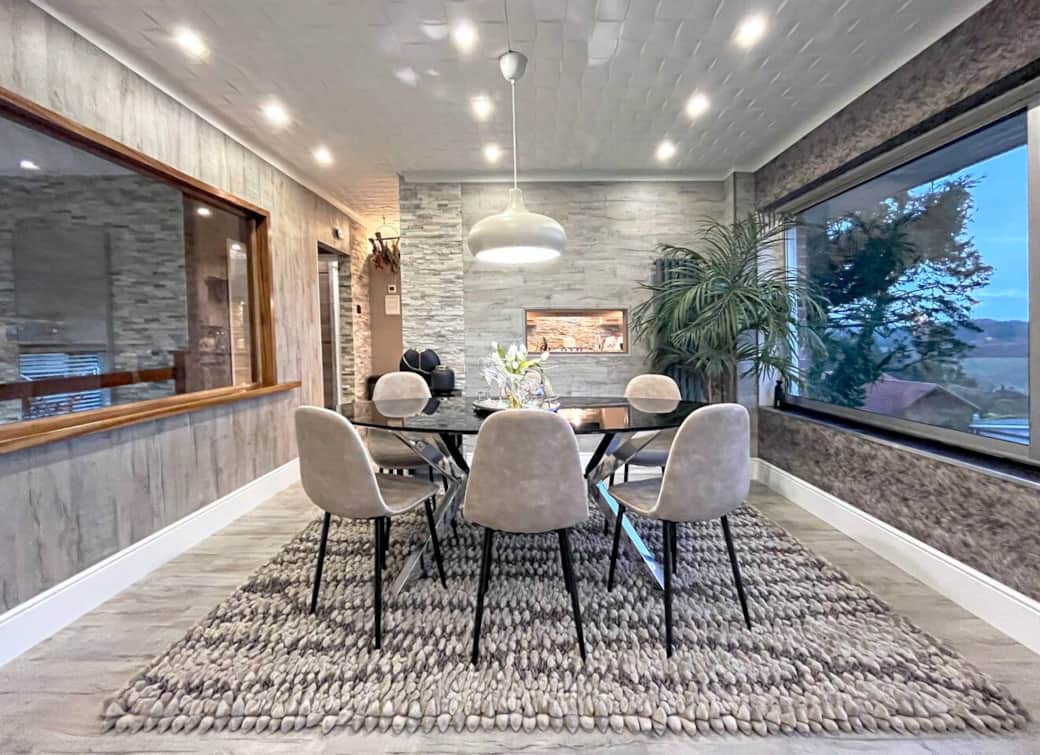 Elegant Dining with a View: Gather around the sleek table in this chic dining area, where expansive windows offer stunning countryside views, creating the perfect backdrop for every meal.