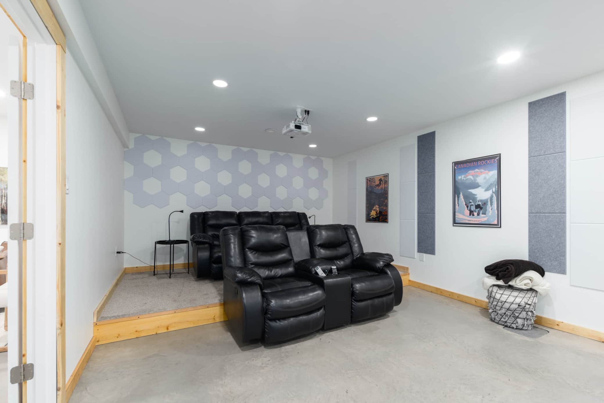 Movie theatre room with dual reclining couches, projector, and surround sound.jpg