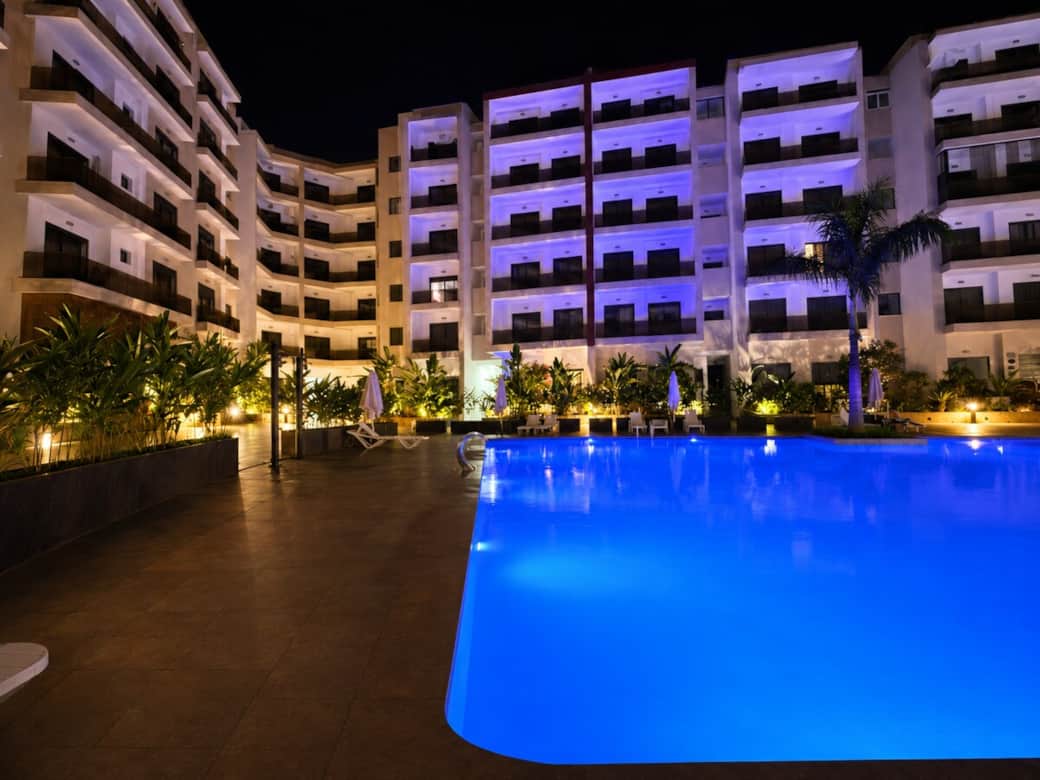 Large illuminated swimming pool at night, creating a luxurious and tranquil atmosphere. The elegant lighting and contemporary surroundings offer a premium vacation experience. Large illuminated swimming pool at night, creating a luxurious and tranquil atmosphere. The elegant lighting and contemporary surroundings offer a premium vacation experience.