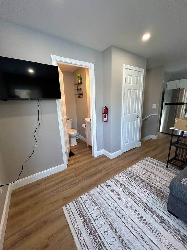 50" TV, looking into bathroom, closet will have bath towels for the amount of guests in your stay, and you can see the stairs down to the bedrooms.