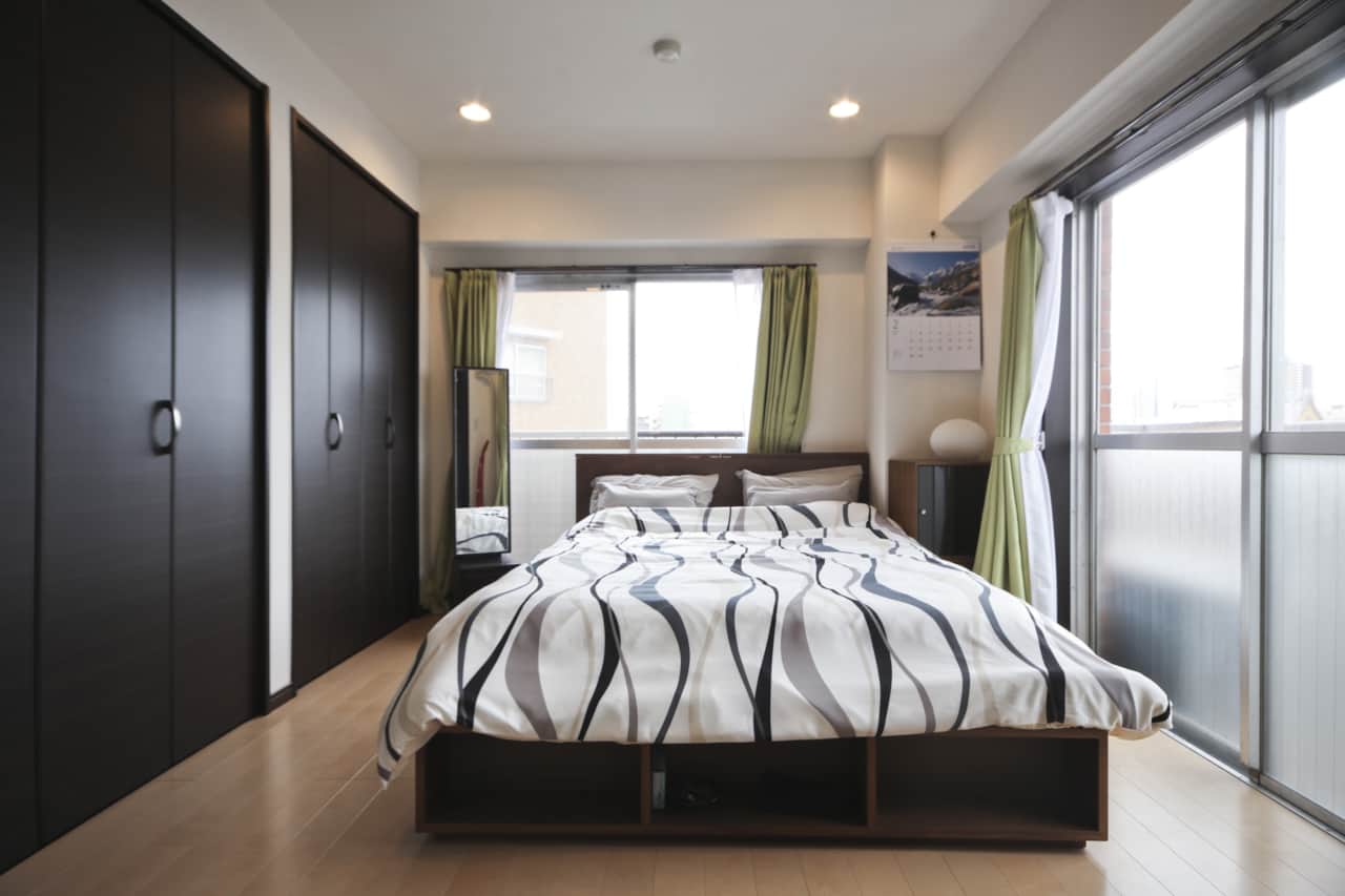 Unwind in a peaceful, sunlit bedroom with ample storage and city outlook