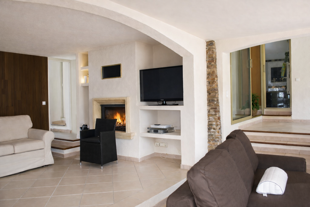 Salon lumineux avec cheminée et téléviseur