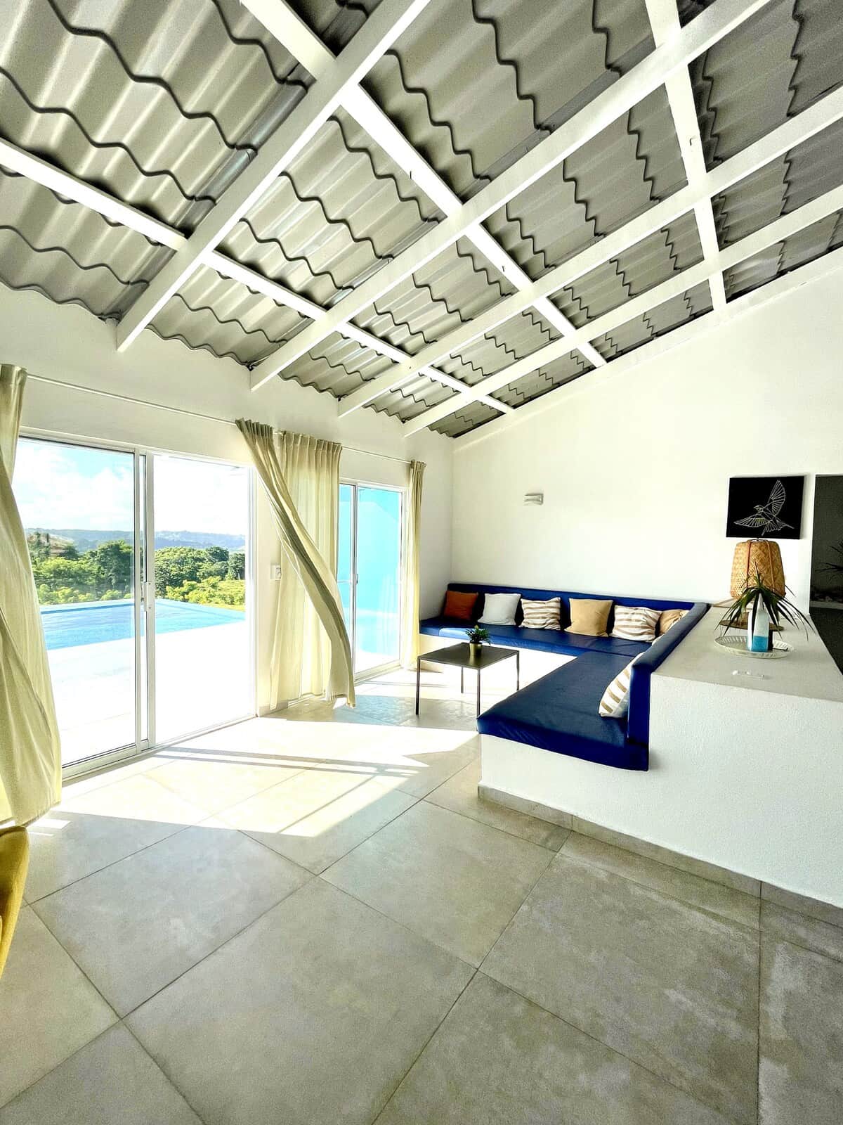 Blue House living room with open doors and white timber ceilings