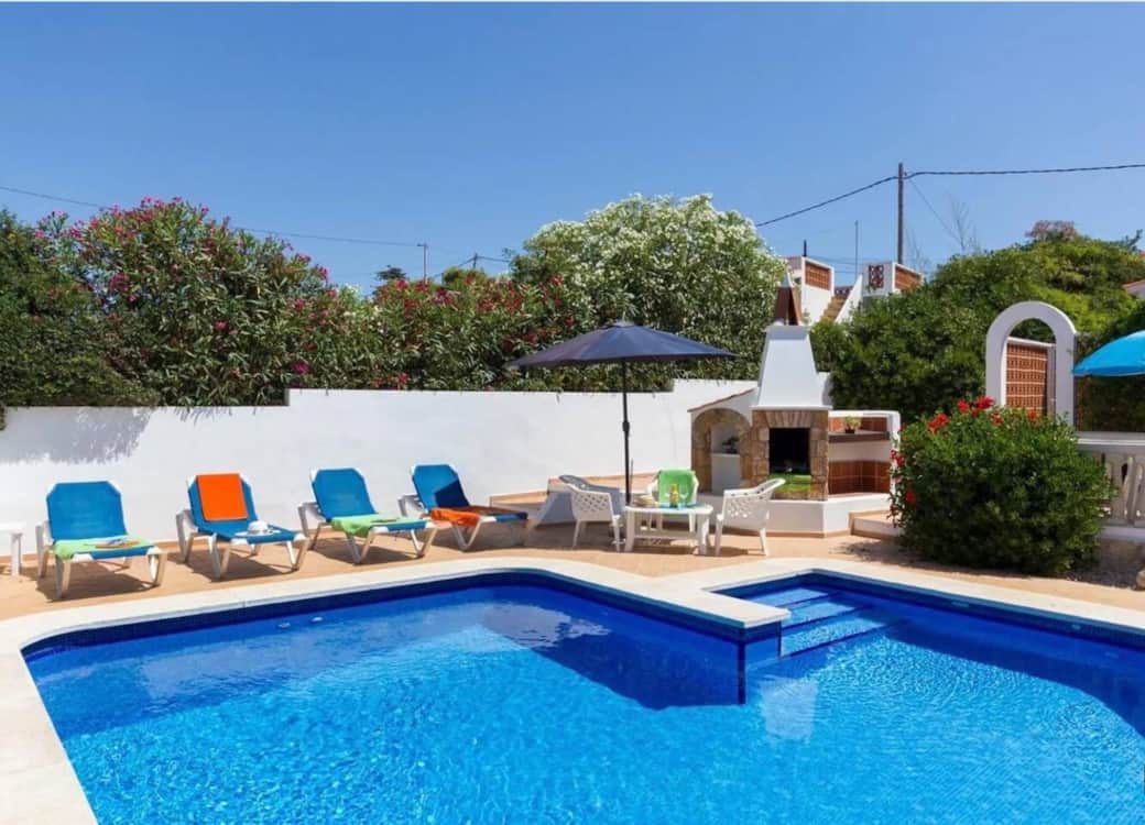 Pool and patio with sun loungers and umbrella
