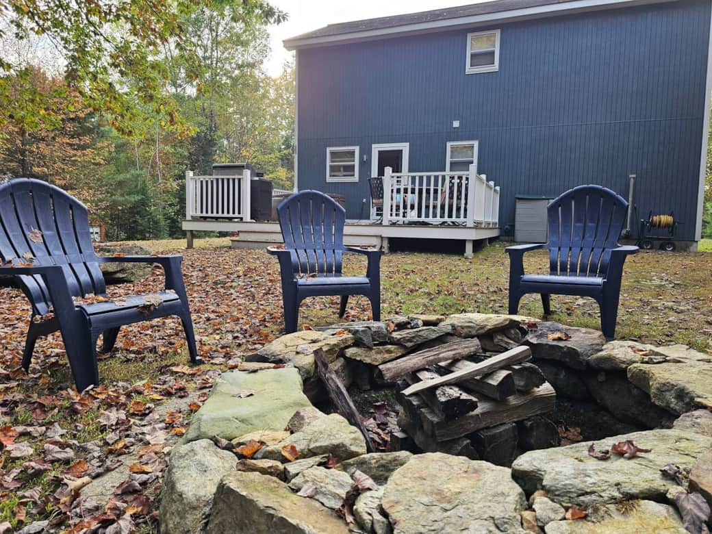 Unwind outdoors around the rustic stone firepit, complete with Adirondack chairs. Perfect for evenings under the stars, just steps from the back deck and surrounded by peaceful woods.