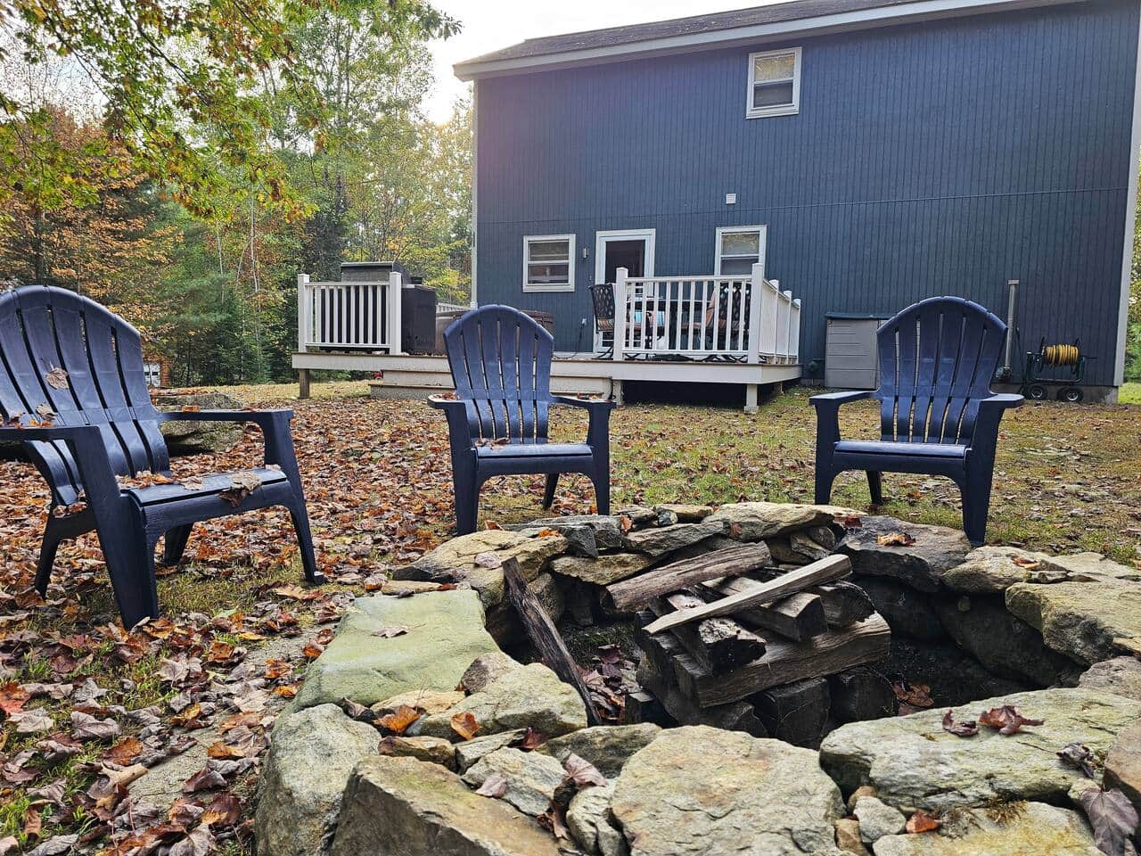 Unwind outdoors around the rustic stone firepit, complete with Adirondack chairs. Perfect for evenings under the stars, just steps from the back deck and surrounded by peaceful woods.