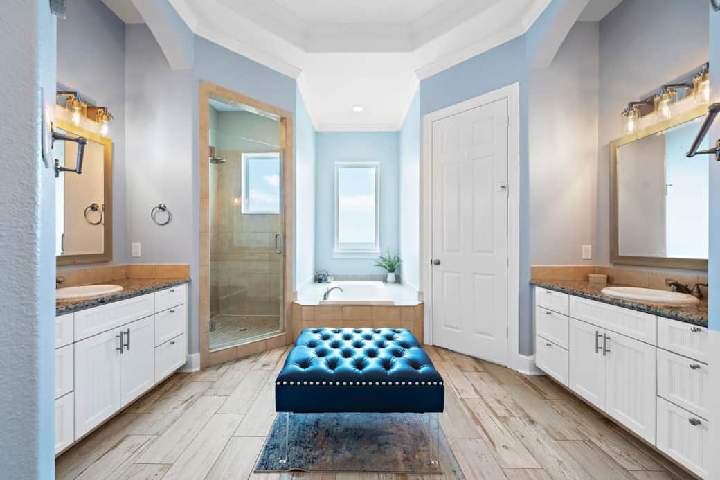 Master Bathroom with seating, double vanity, shower, and view tub