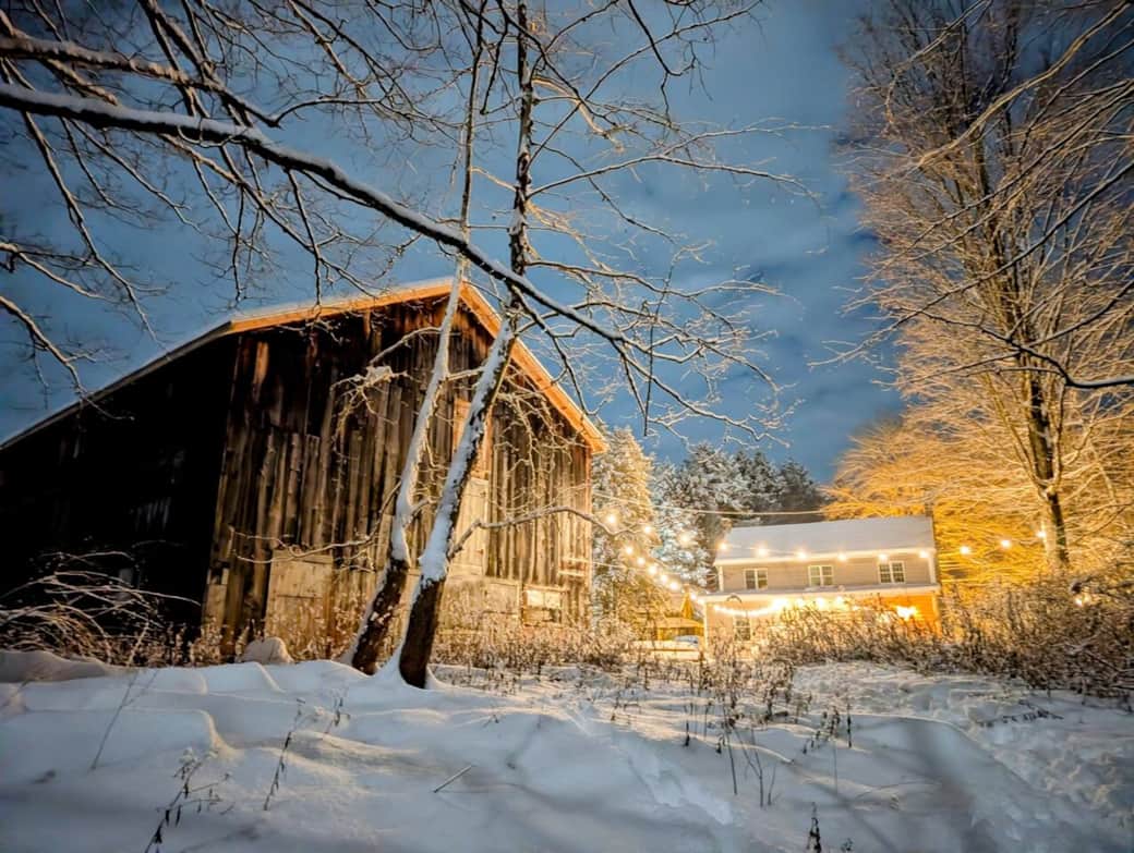 The side of the barn with the back of the house beyond 