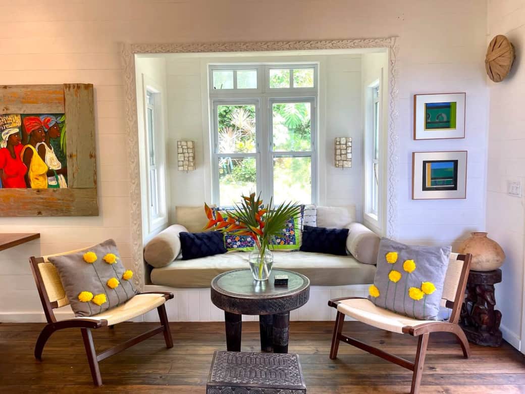 Living room has a twin size daybed and opens up onto the pool area and outdoor porch as well as dining room
