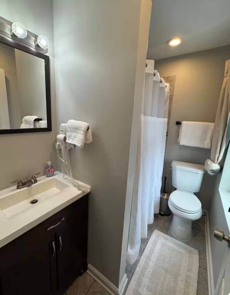 small bathroom has a bathtub and a vanity.