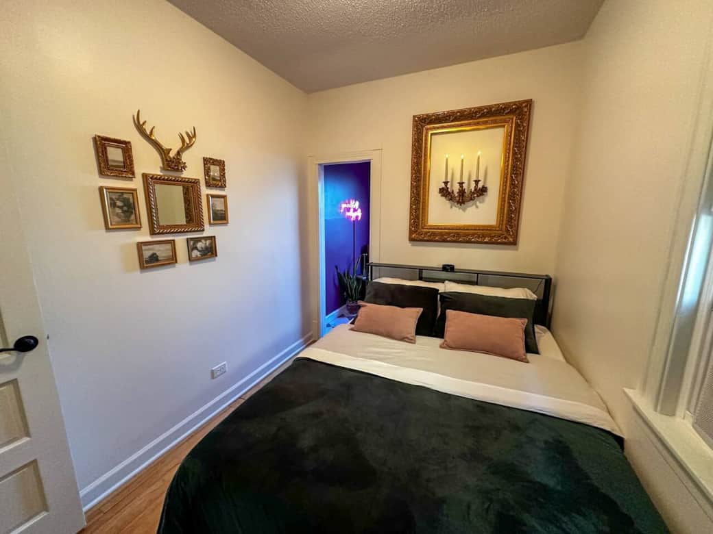 A cozy queen bed with light up head board and room darkening shade. The head board also has plug points at the top left.
