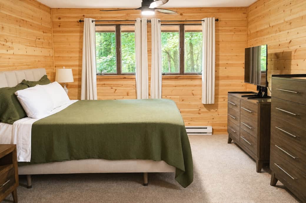 Primary bedroom with hotel-style bedding, a sleep number bed and a smart tv.