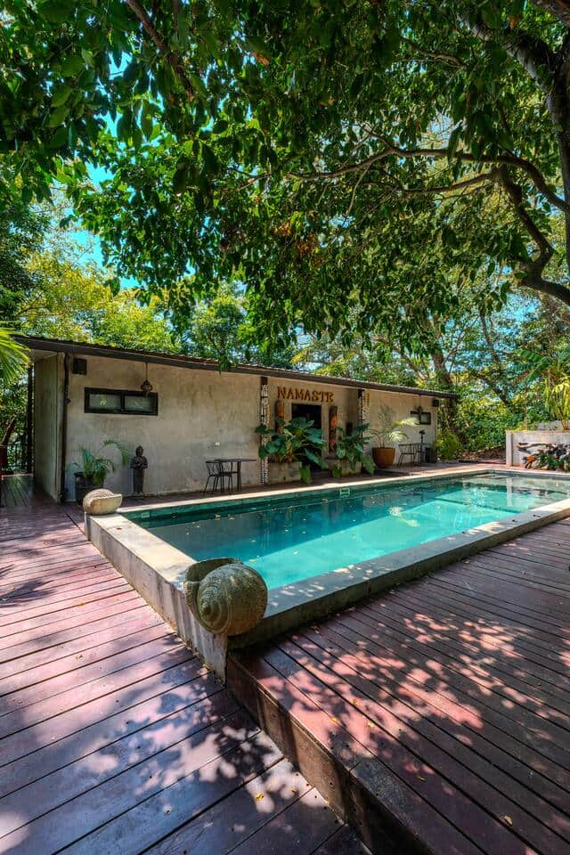 Tree-shaded pool beside a wooden deck at Saboga Lodge, Saboga Island, Panama
