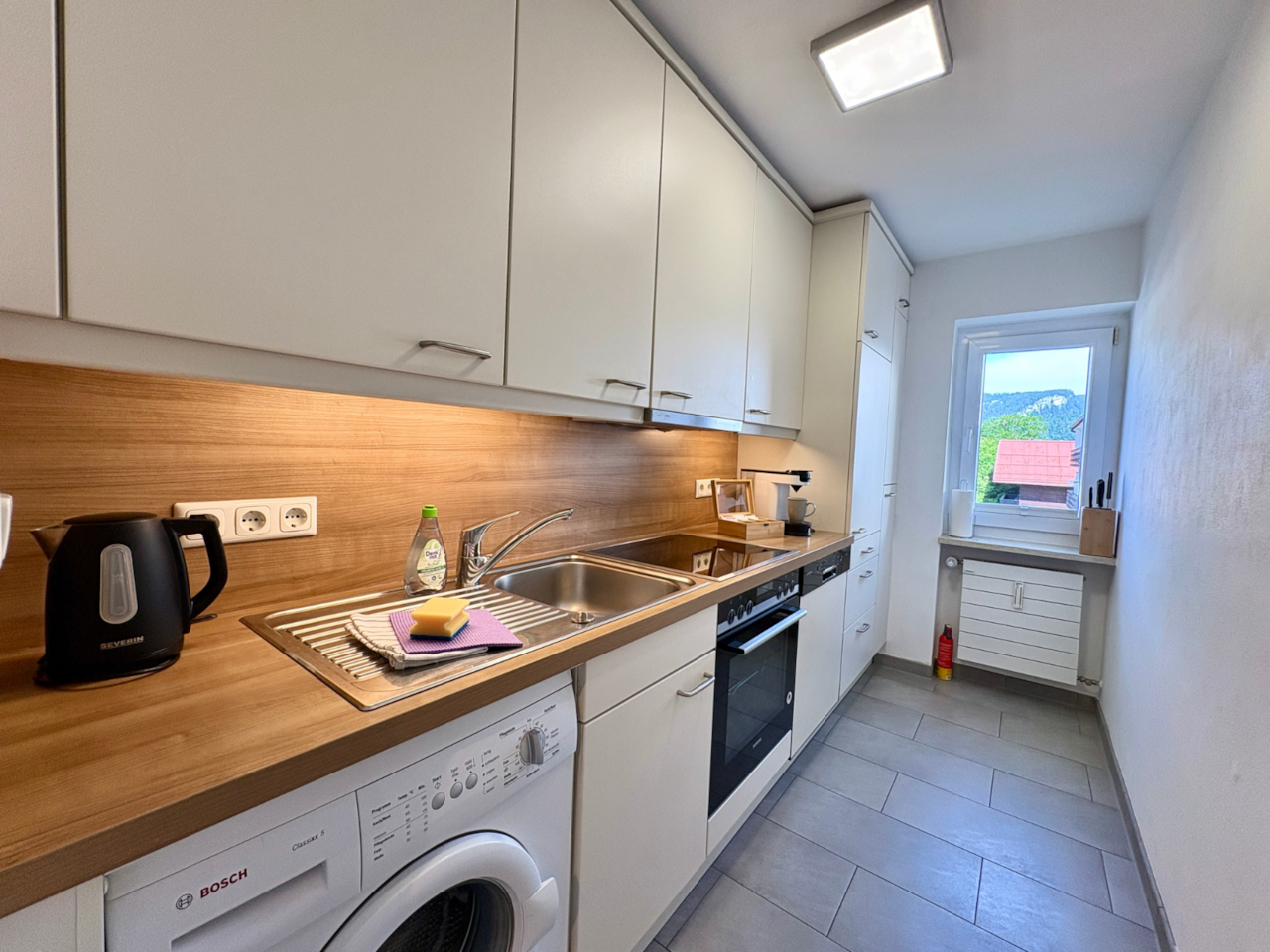 Küche mit Spülmaschine und Backofen