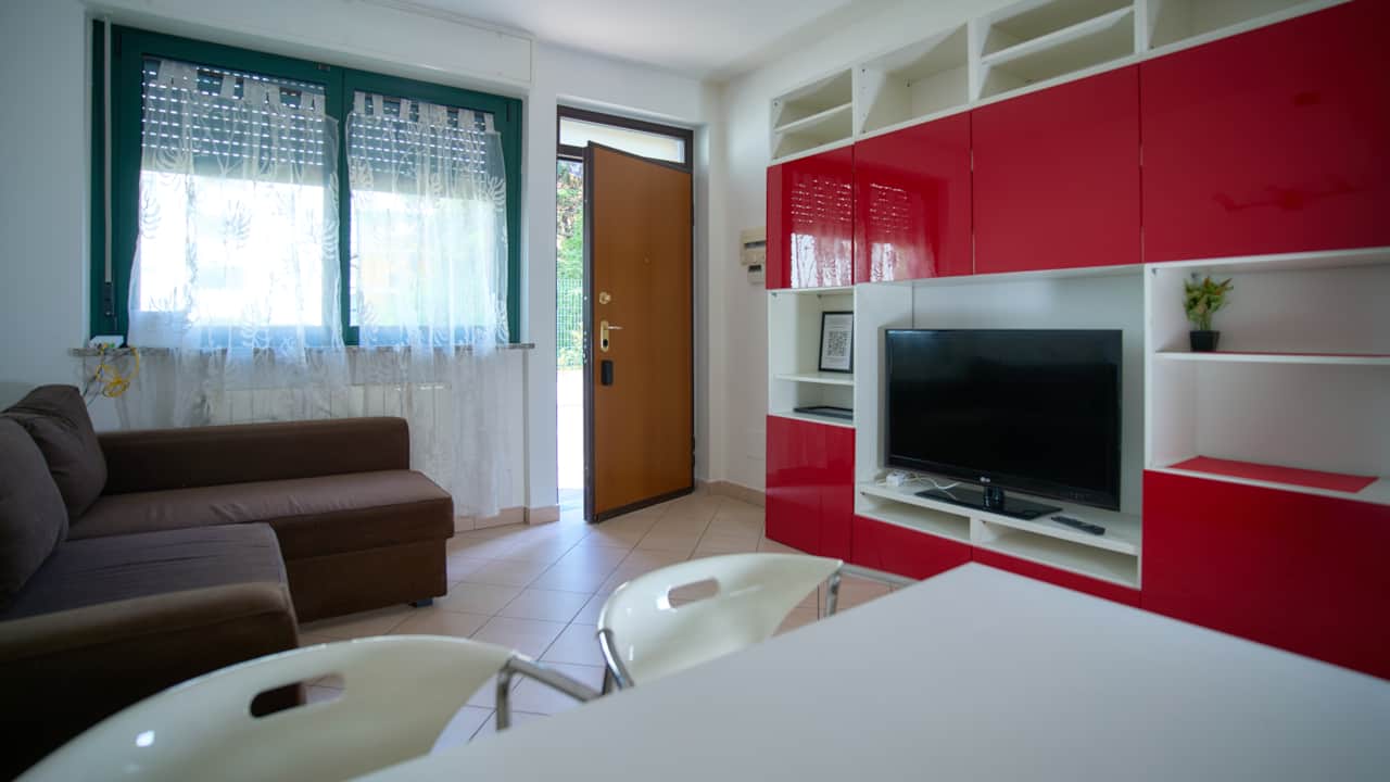 Living room with red wall, TV and sofa, in Monza