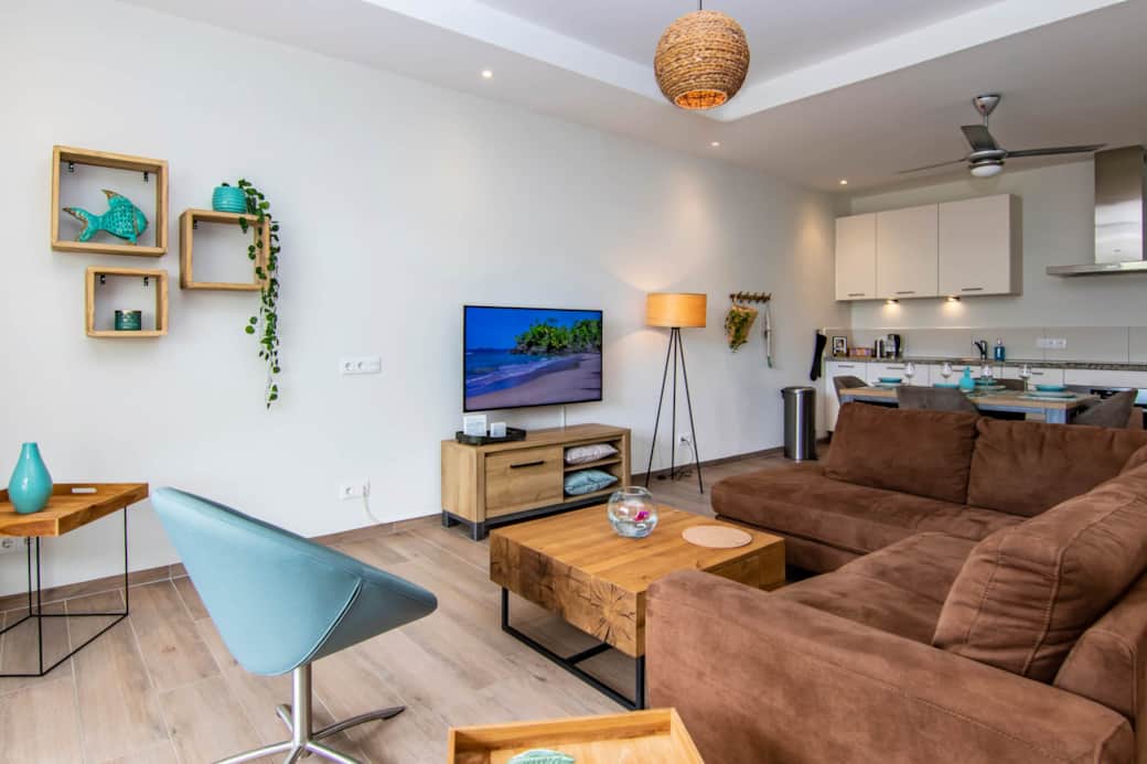 Lounge set with 50 inch smart TV in the living room with open kitchen.
