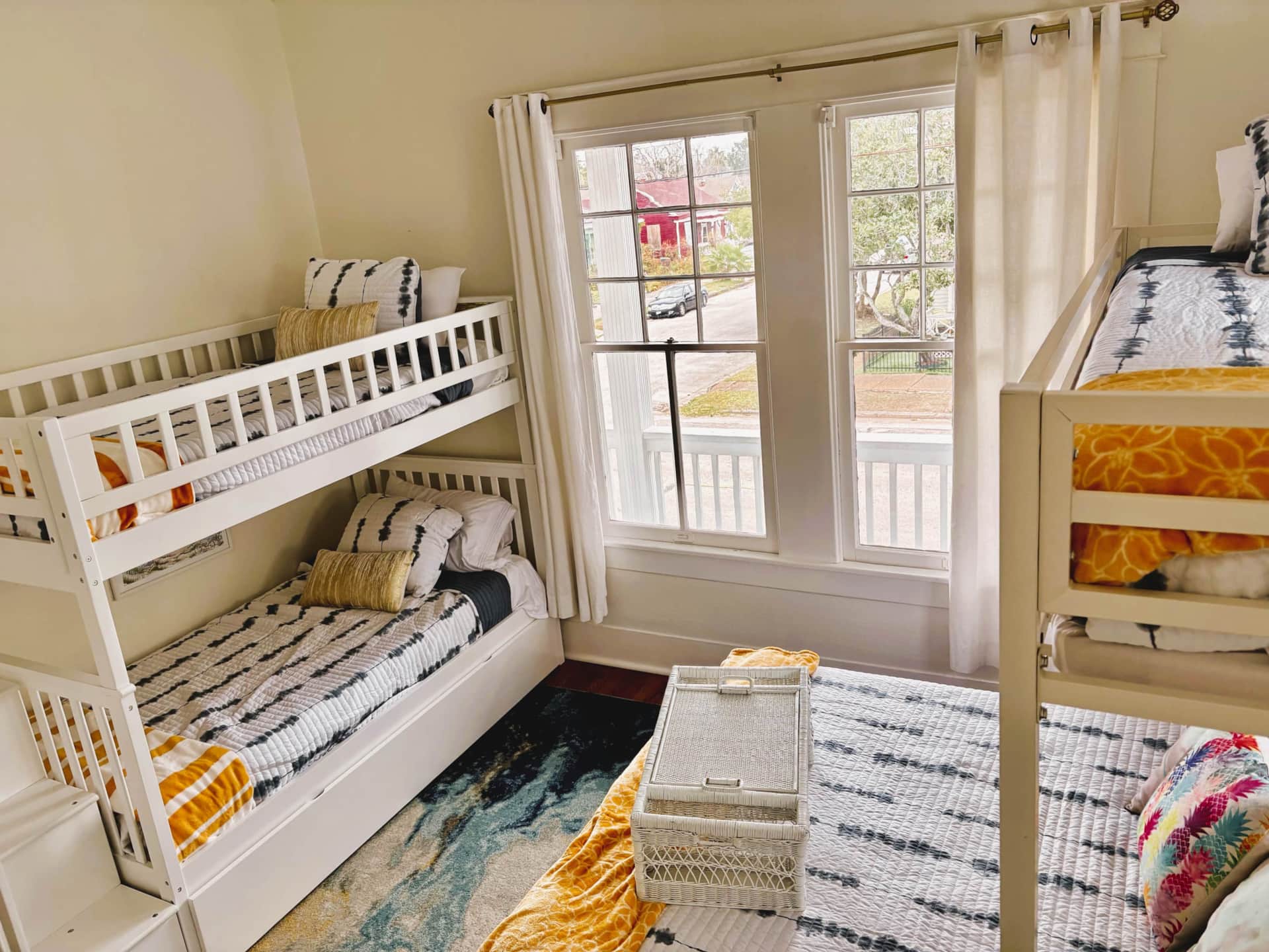 Spacious bunk room at White Magnolia Galveston vacation rental with queen and twin beds.